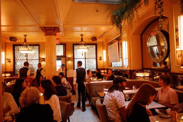 Interior view of Cafe Chelsea at the Chelsea Hotel in Manhattan with a group of people sitting at tables in a restaurant