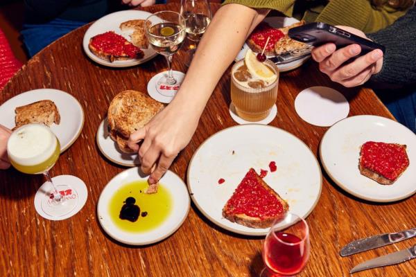 A person enjoying toast with jam and a drink at Resy Bar Americano