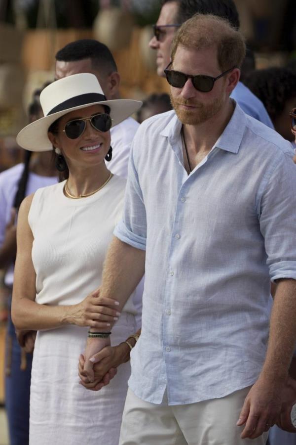 Prince Harry and Meghan Markle holding hands as they arrive in San Basilio de Palenque, Colombia