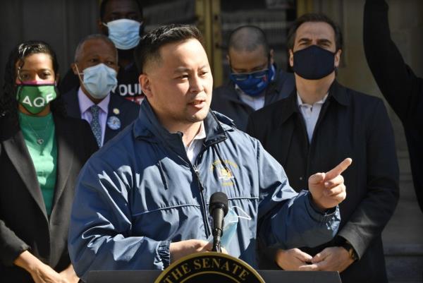 New York Assemblyman Ron Kim at a news conference, announcing new revenue plans by ending tax breaks for the rich, standing next to Democratic lawmakers