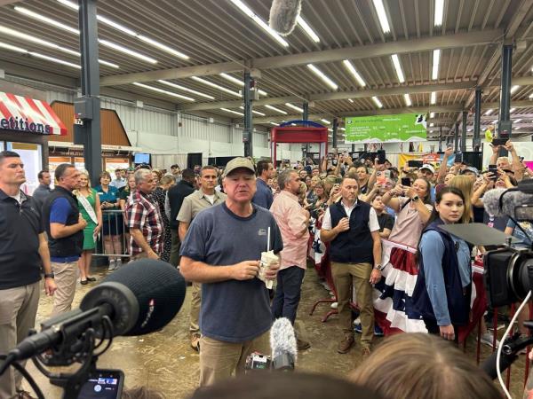 Gov. Tim Walz surrounded by a crowd of fairgoers at the Minnesota State Fair.